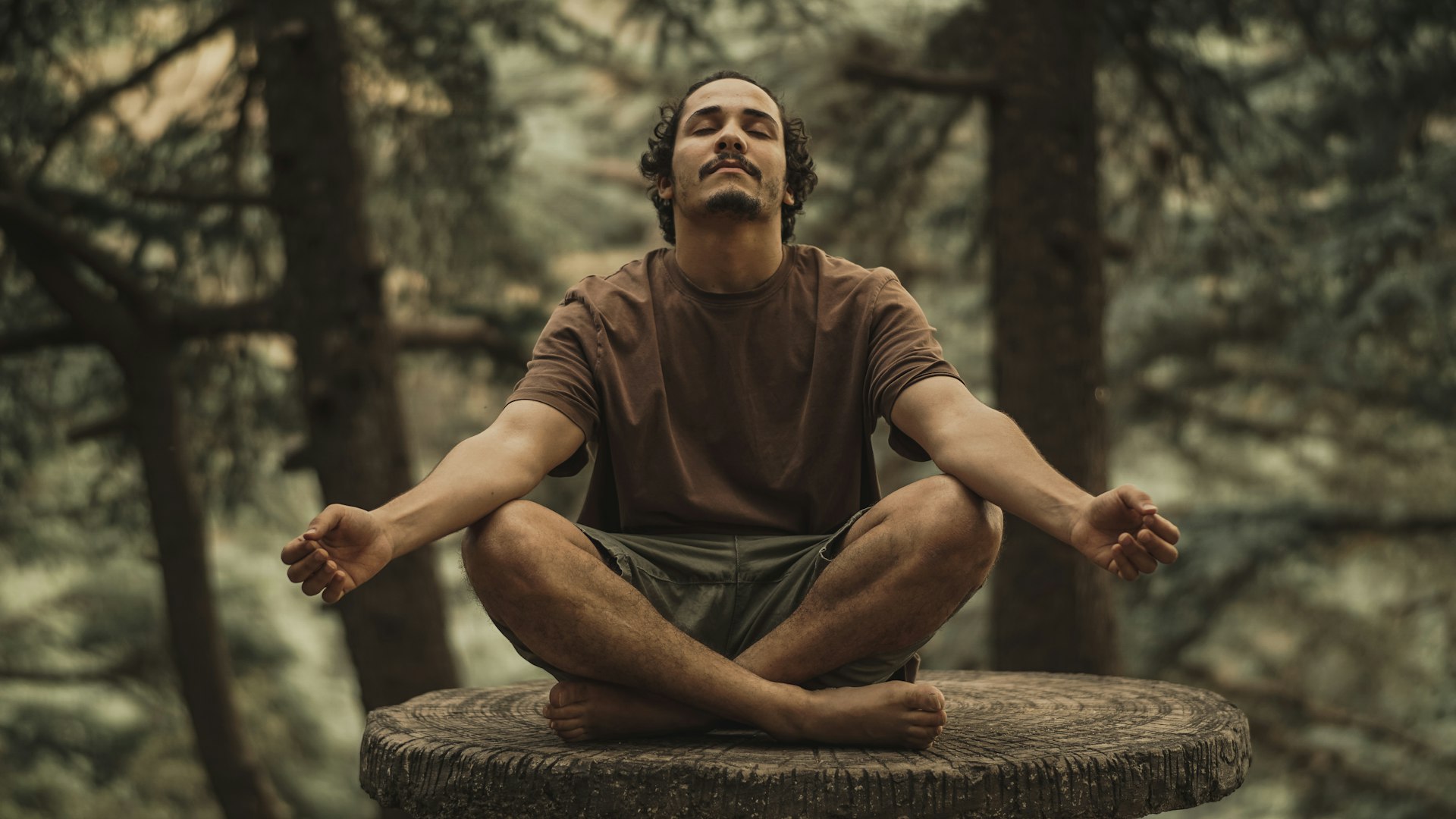Hombre haciendo una meditación consciente en el bosque
